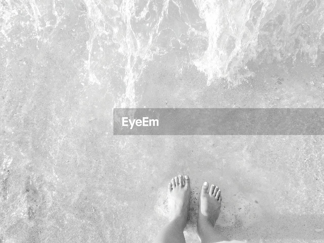 LOW SECTION OF WOMAN SWIMMING IN WATER
