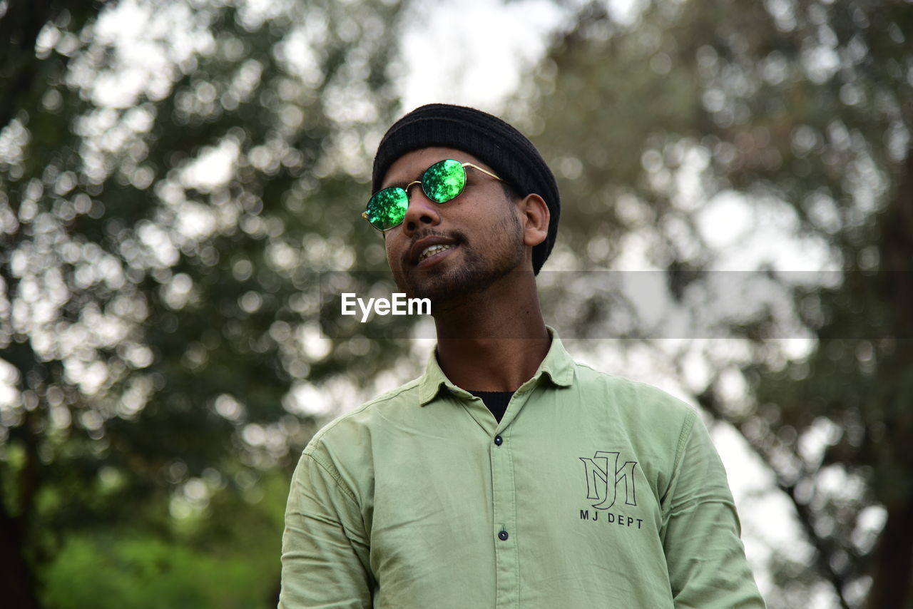 PORTRAIT OF YOUNG MAN WEARING SUNGLASSES