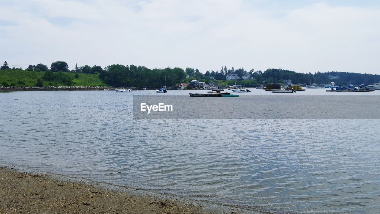 Boats sailing on river against sky