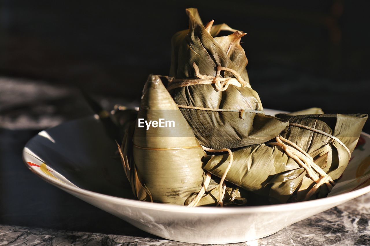 Close-up of food wrapped in leaf on plate at table