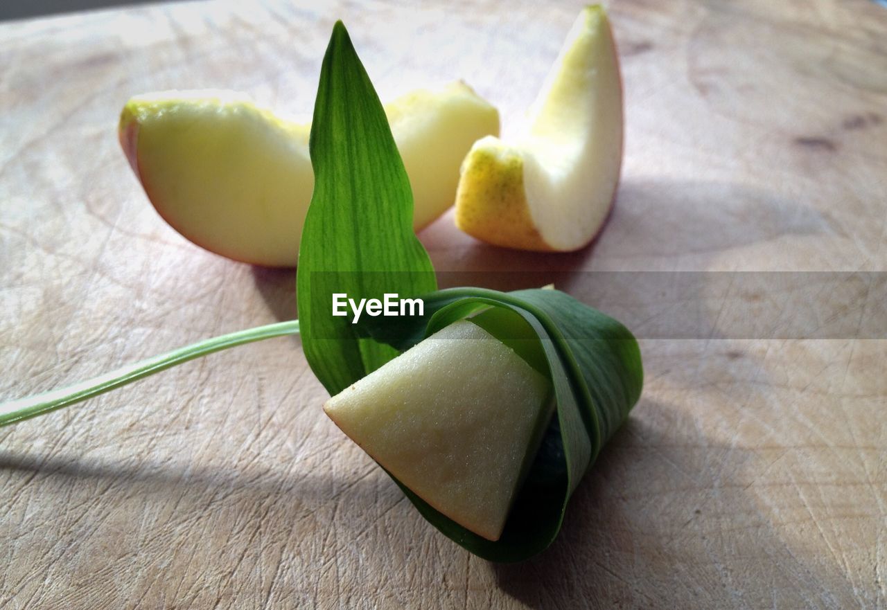 High angle view of fresh apple slices with green leaf