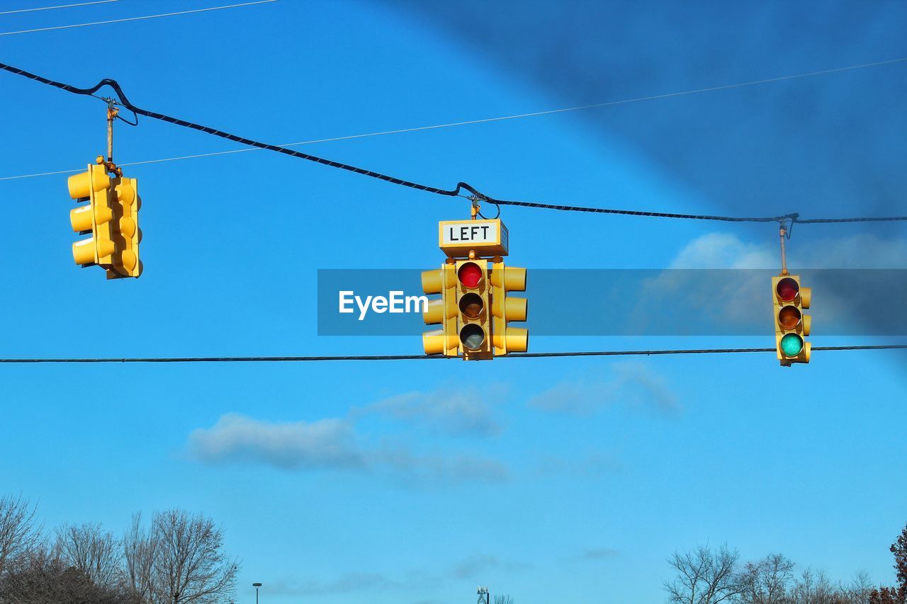 Low angle view of road signals against blue sky
