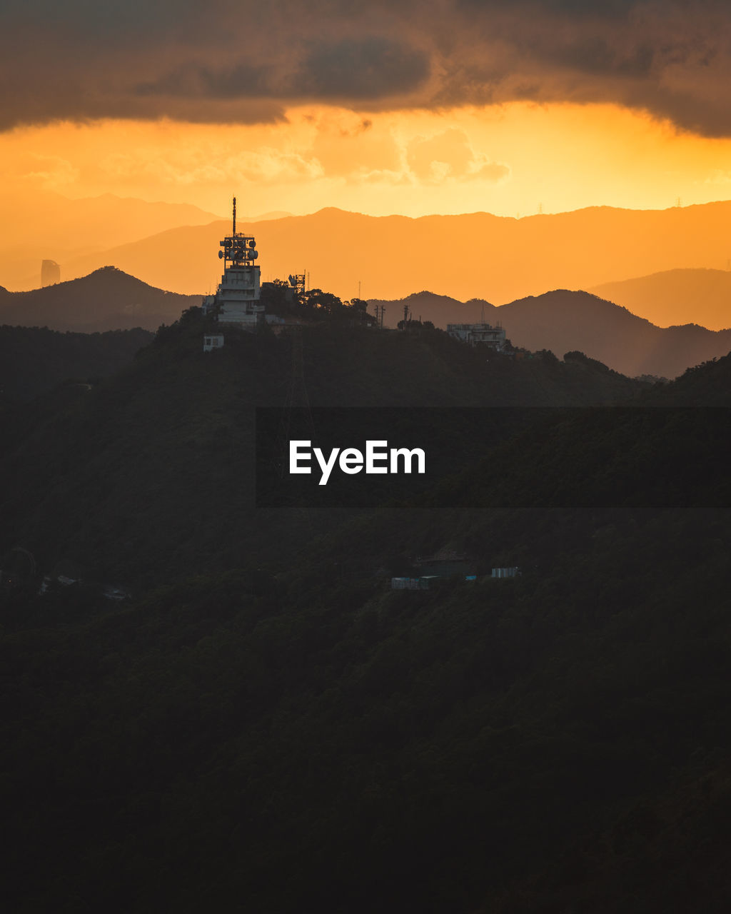 Scenic view of silhouette mountains against orange sky