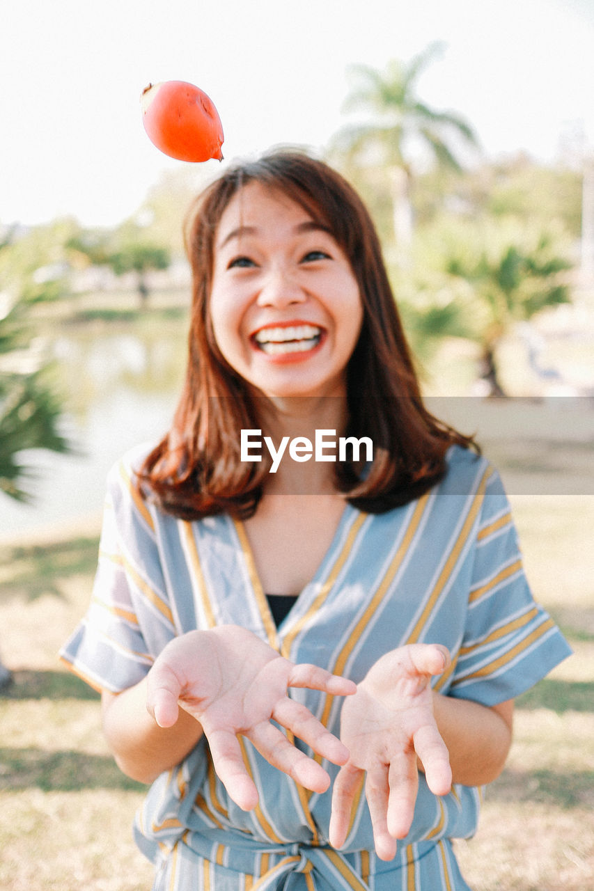 Smiling woman throwing food outdoors