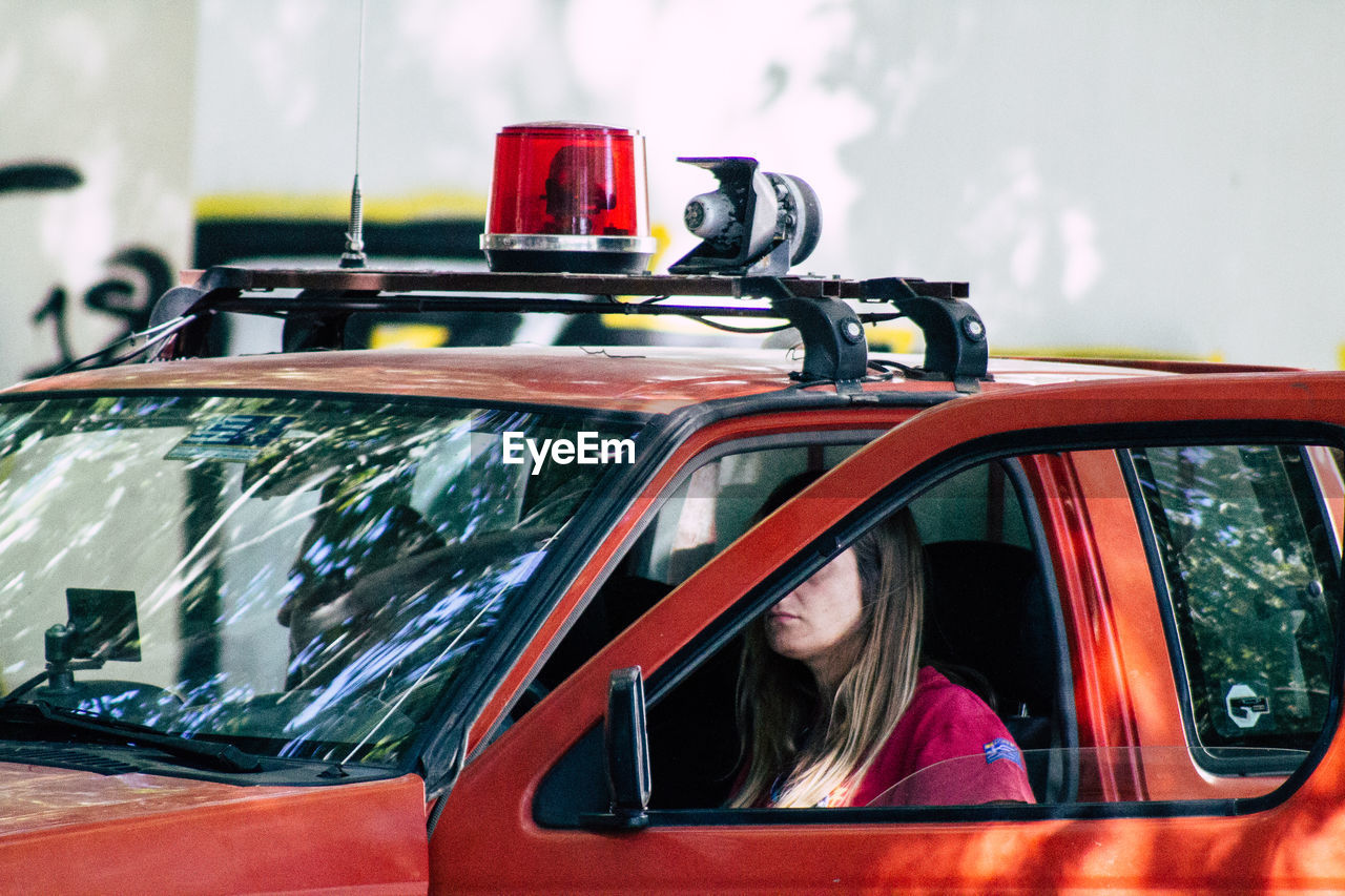 PORTRAIT OF WOMAN SITTING IN CAR