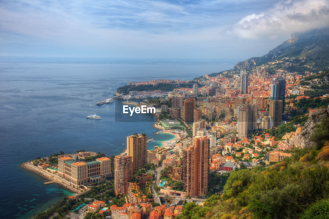 High angle view of buildings by sea against sky