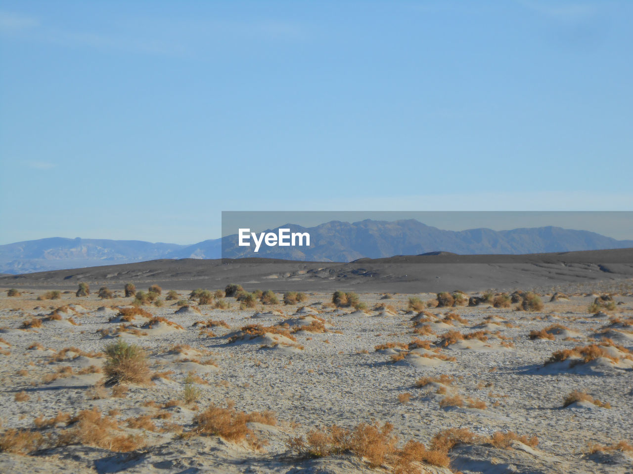 scenic view of desert against clear blue sky