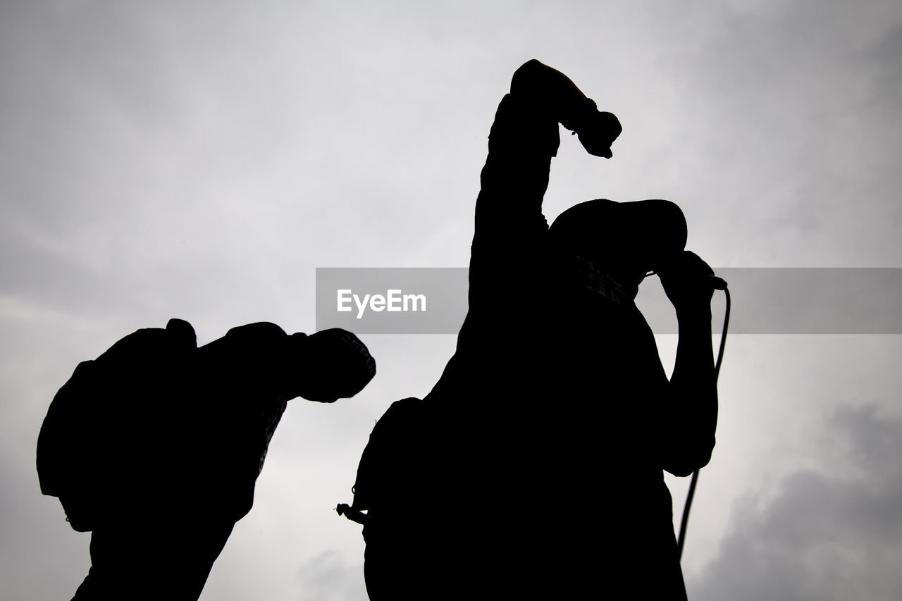 Low angle view of silhouette public speaker giving speech against sky