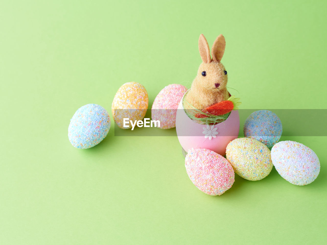 Happy easter concept. artificial cute bunny on the shells egg on green background. copy space.