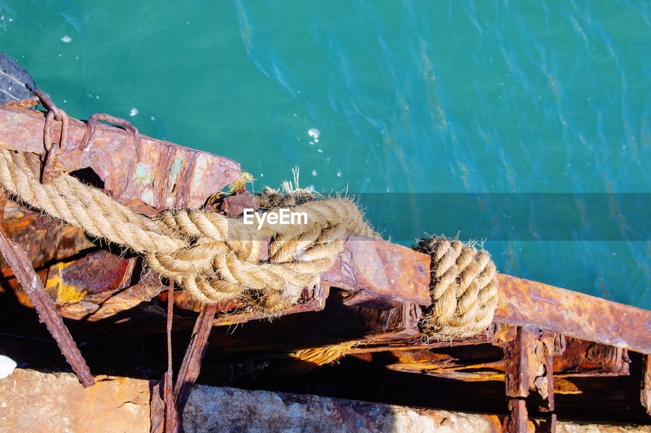 High angle view of rope tied on rusty metal