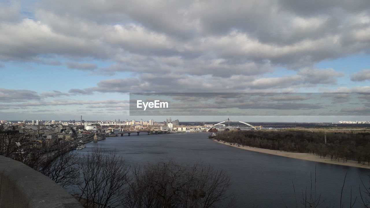 RIVER AMIDST BUILDINGS AGAINST SKY