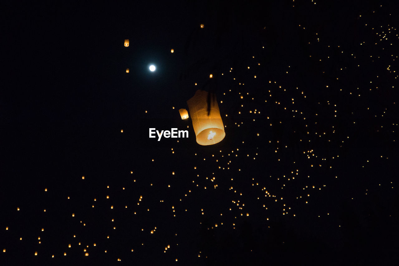 LOW ANGLE VIEW OF ILLUMINATED LANTERNS AGAINST SKY