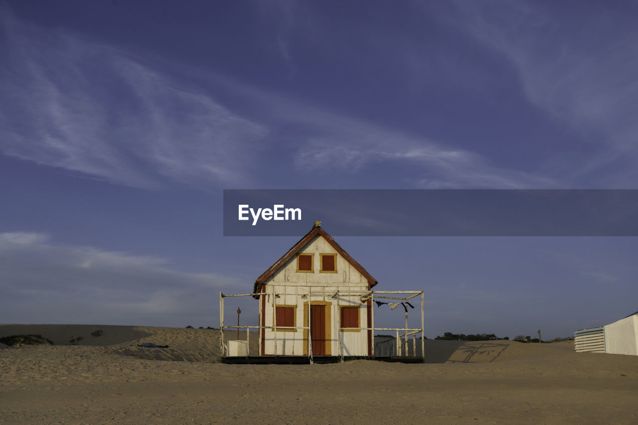 HUT ON BEACH AGAINST SKY