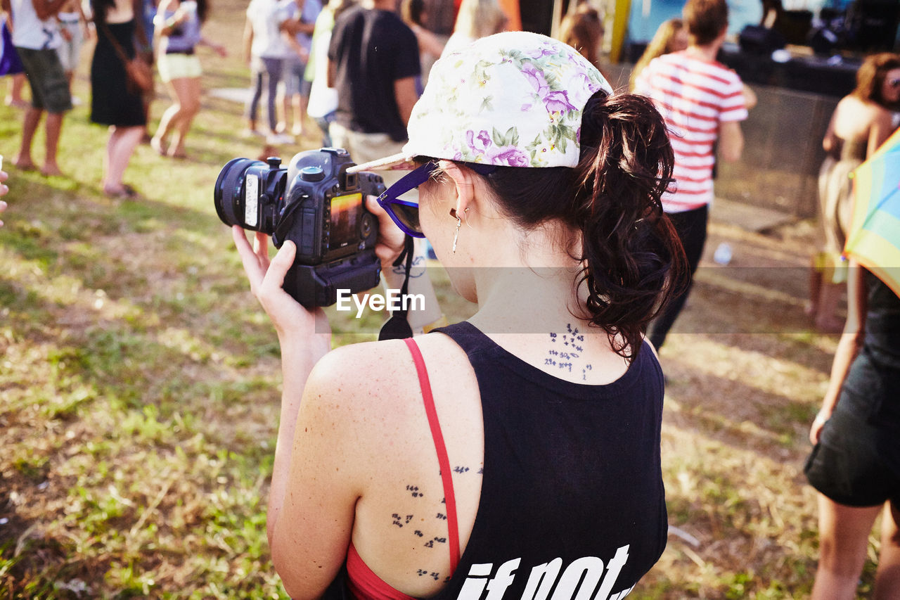 REAR VIEW OF WOMAN PHOTOGRAPHING WITH CAMERA