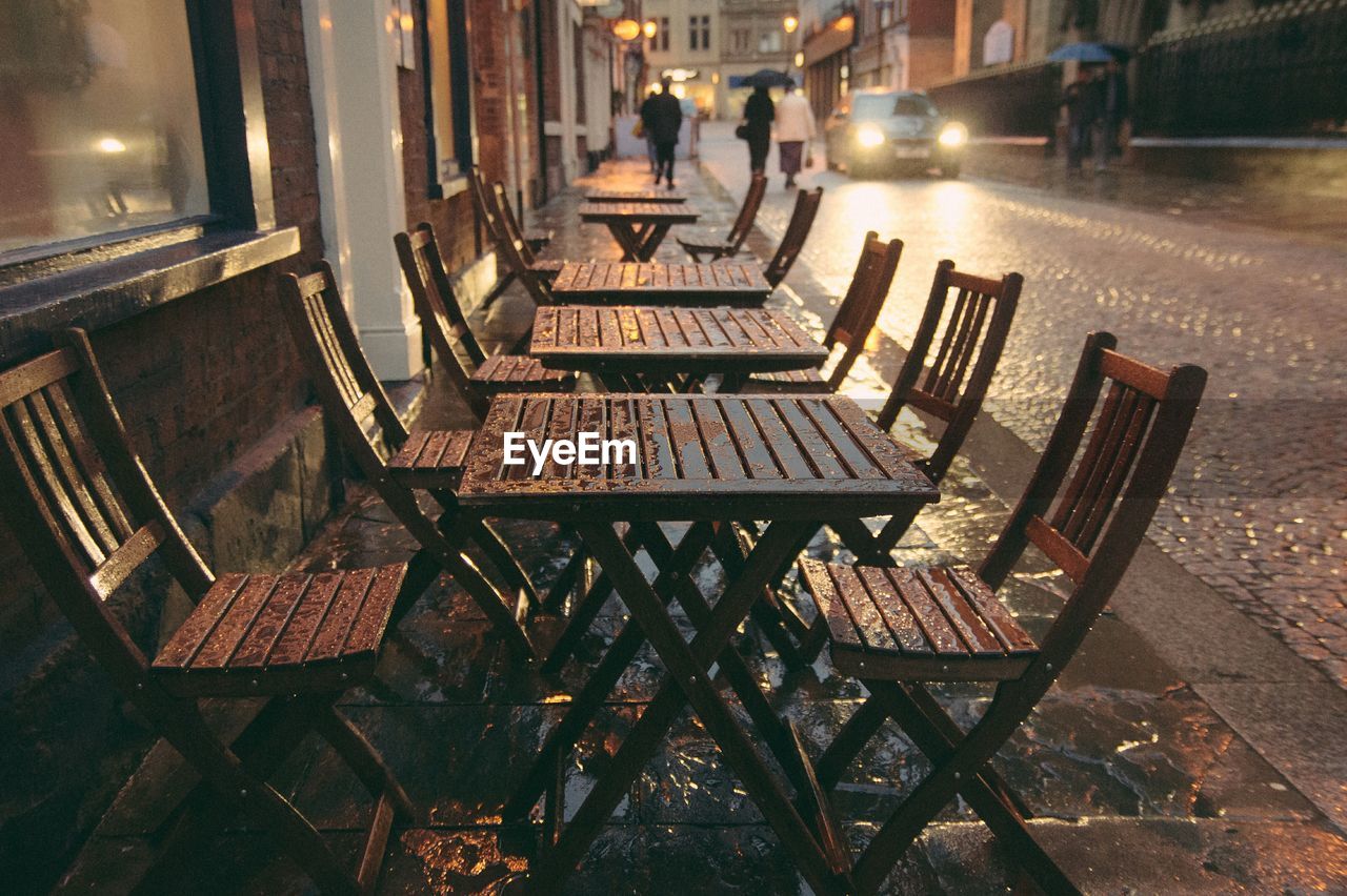 Empty chairs and tables in sidewalk cafe