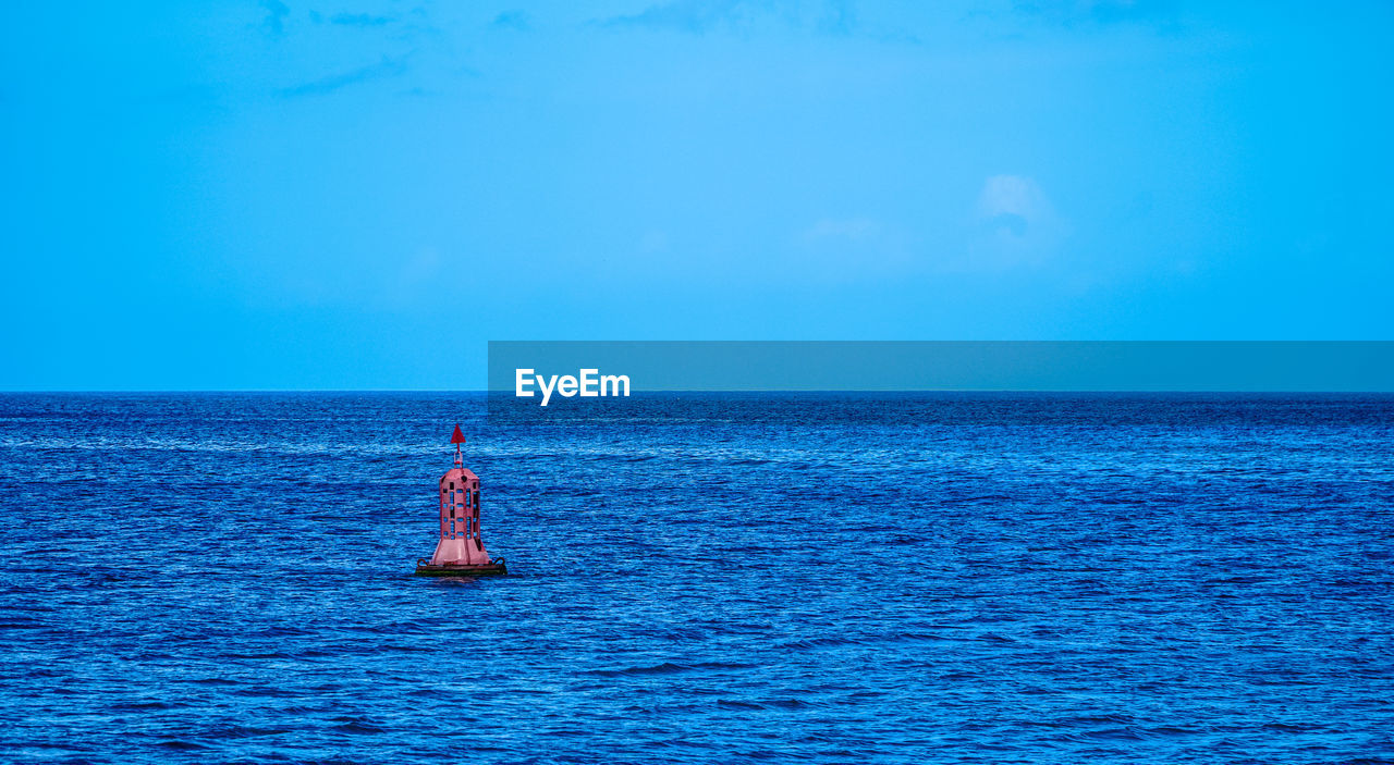 MAN ON SEA AGAINST BLUE SKY