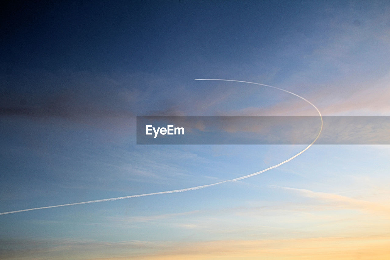 LOW ANGLE VIEW OF VAPOR TRAILS IN SKY DURING SUNSET