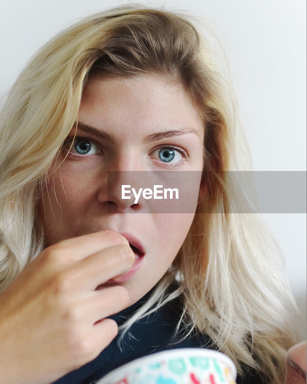 Close-up portrait of woman eating food at home