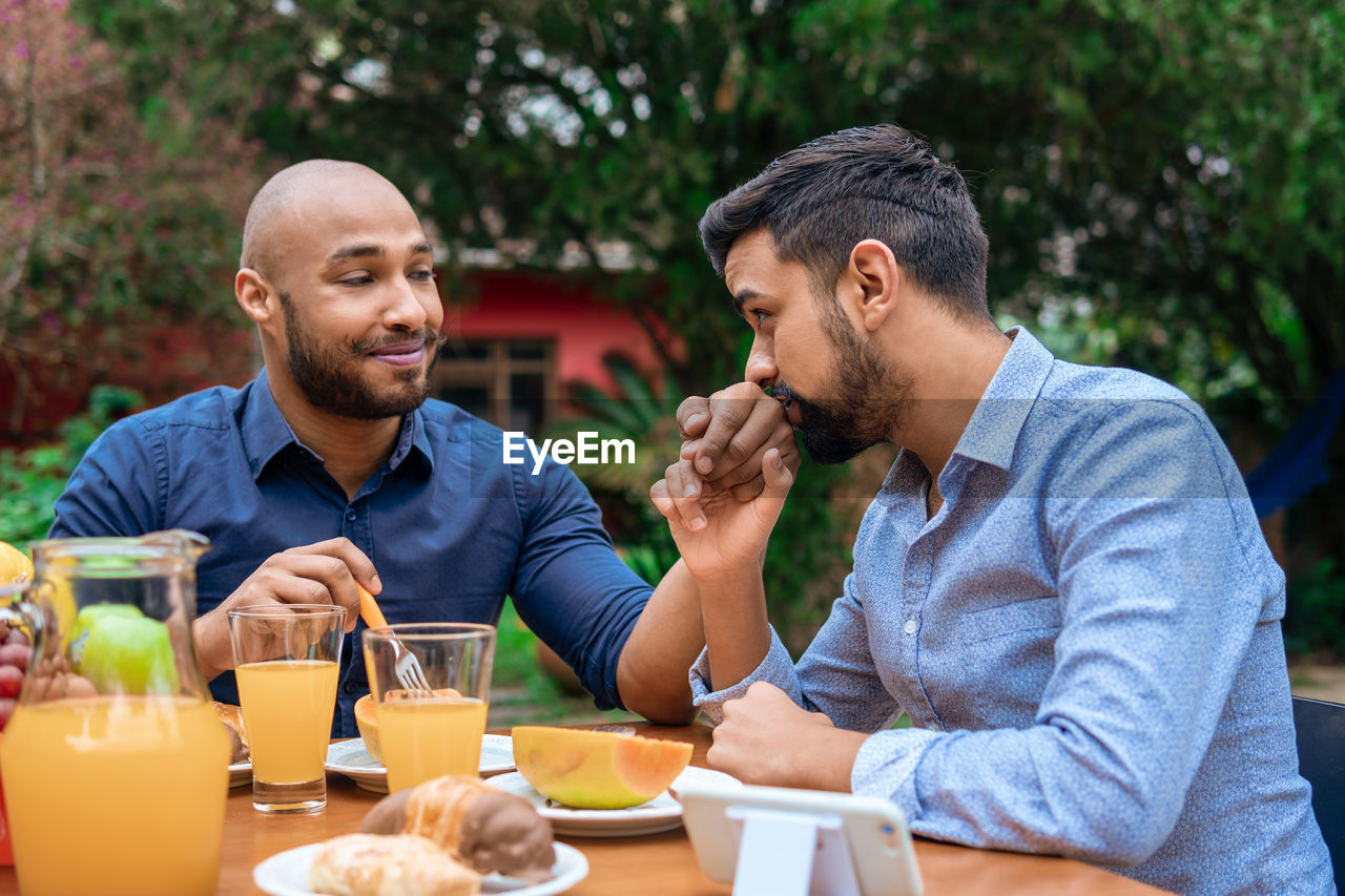 side view of senior man drinking beer while sitting at restaurant