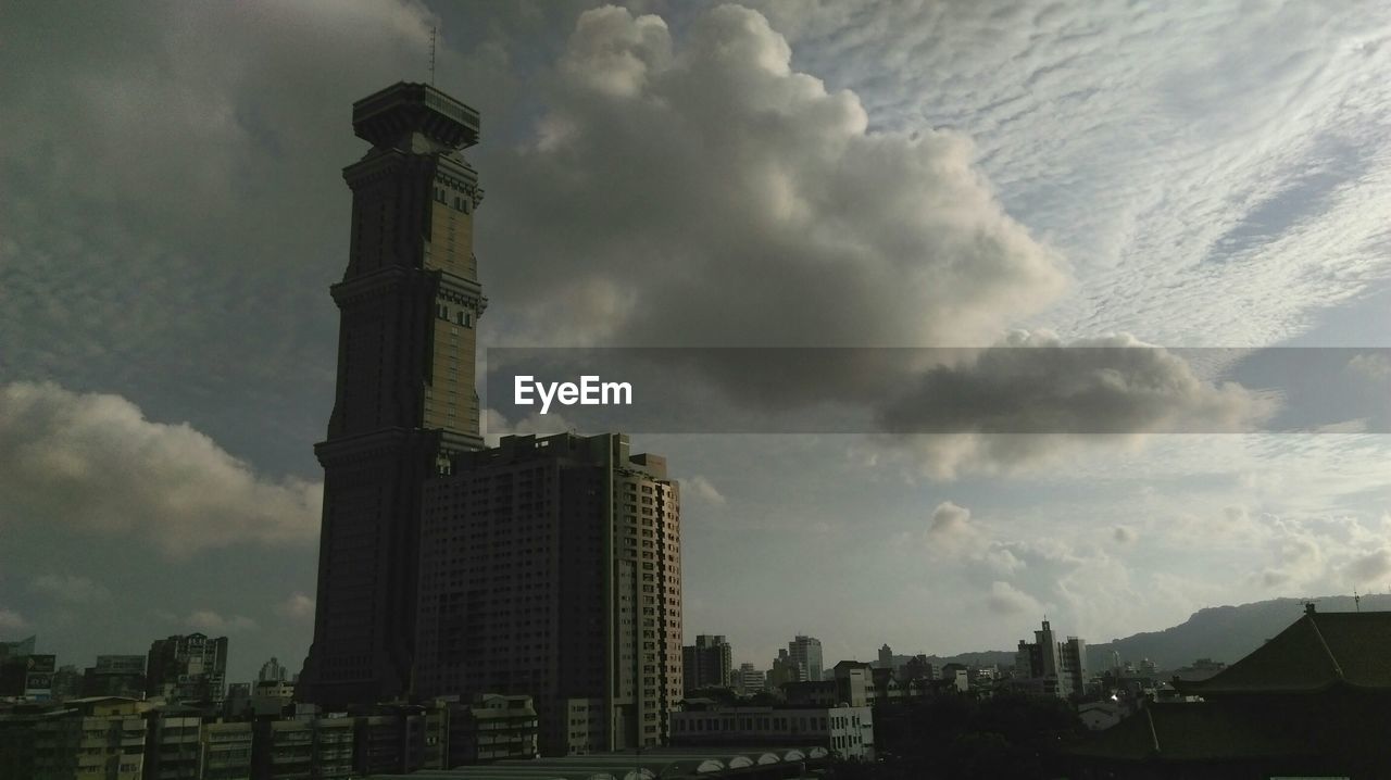 VIEW OF CITY BUILDINGS AGAINST CLOUDY SKY