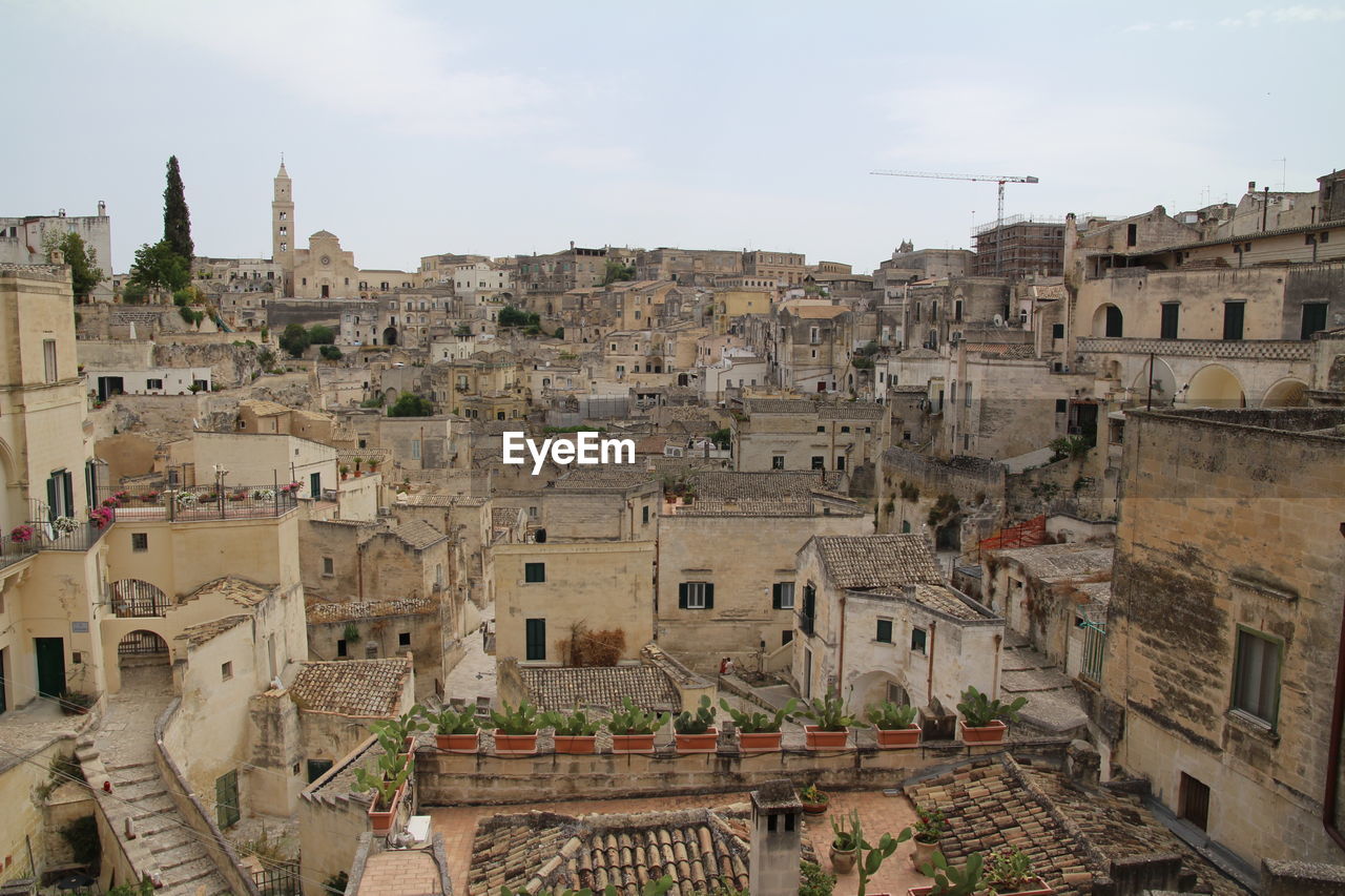 High angle view of old buildings in town against sky