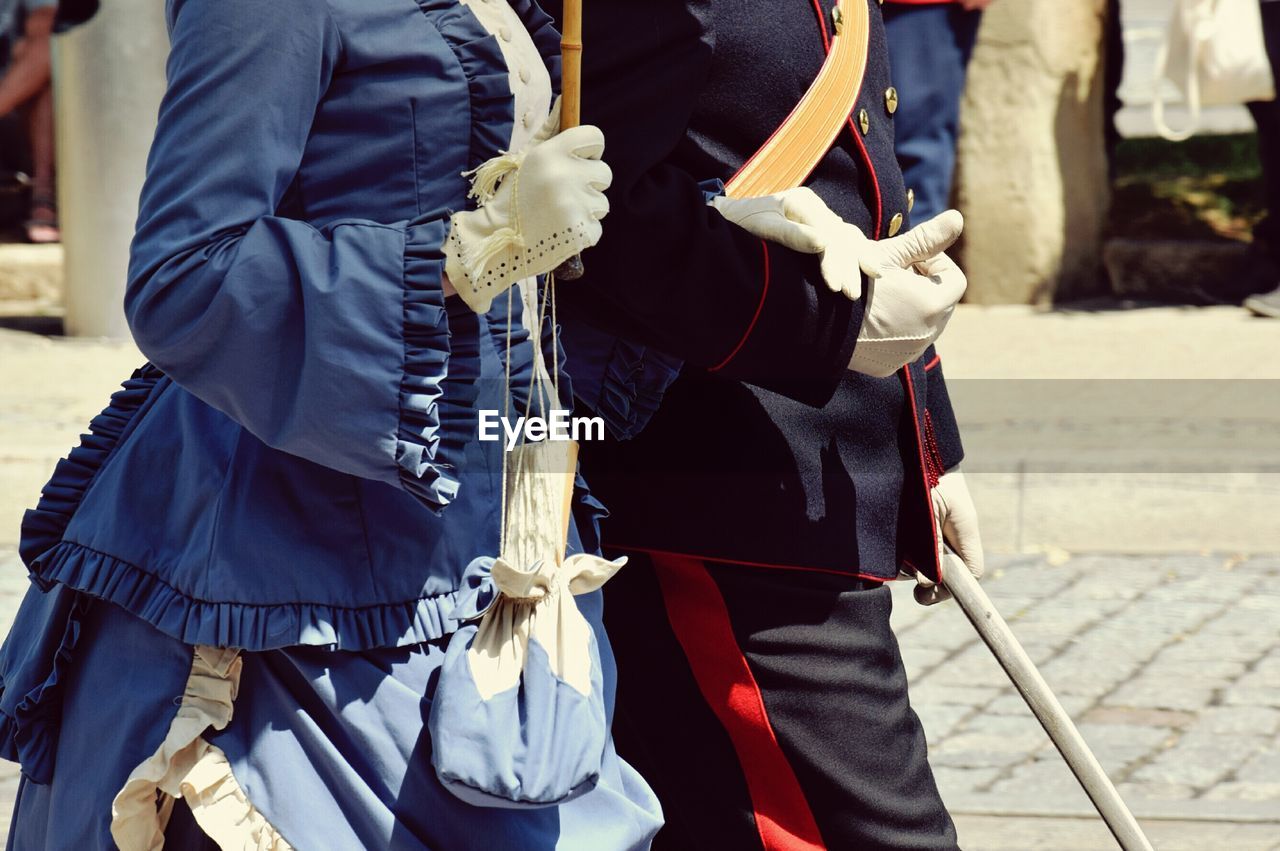 MIDSECTION OF MAN STANDING IN TRADITIONAL CLOTHING