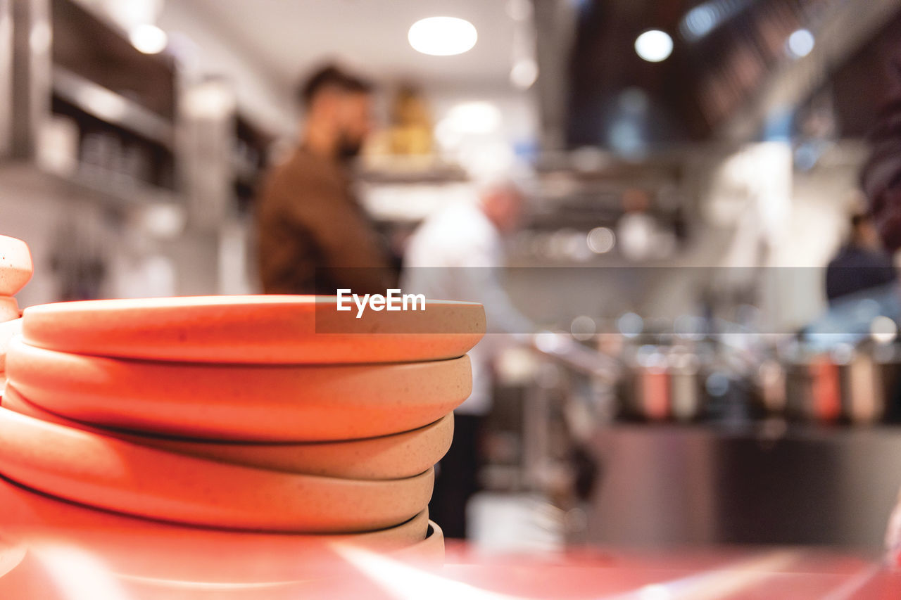 Restaurant kitchen staff preparing food, plates in the focus