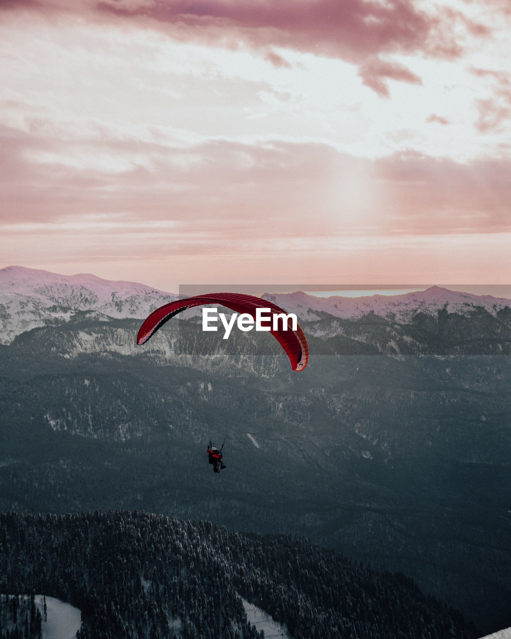 People paragliding over mountain against sky