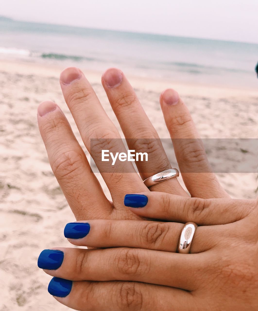 Cropped hands of couple at beach