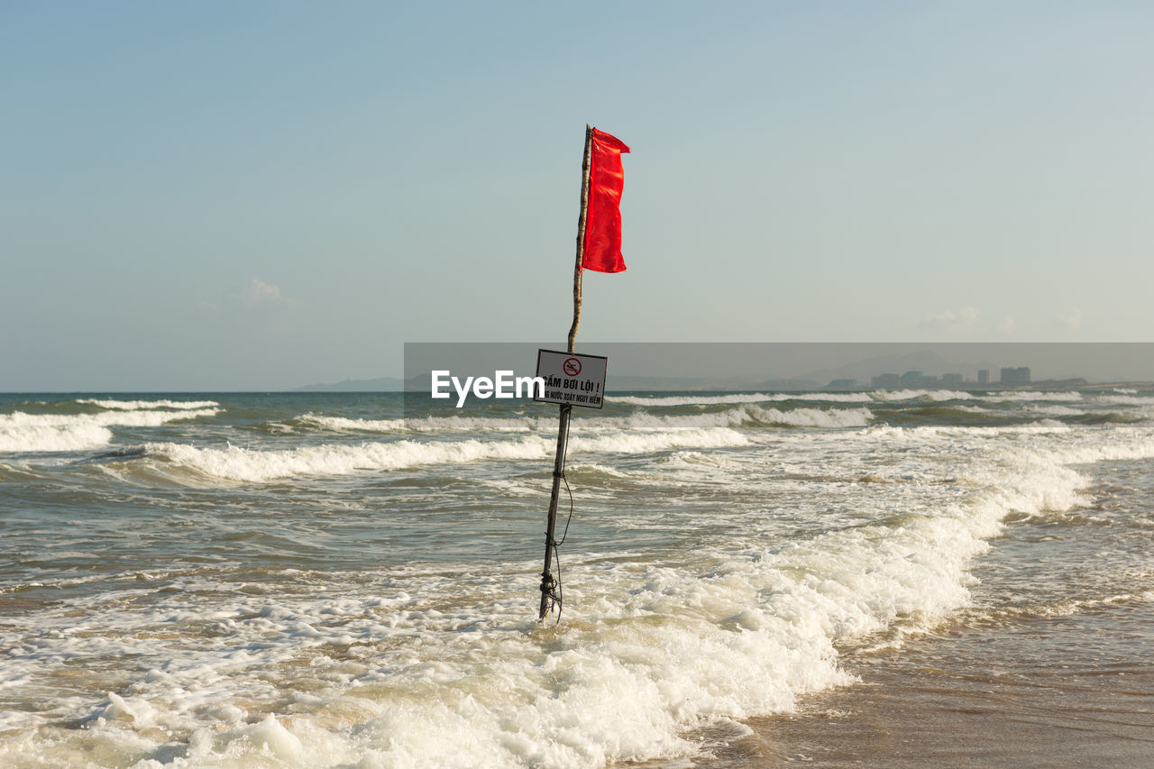 LIFEGUARD SIGN ON BEACH AGAINST SKY