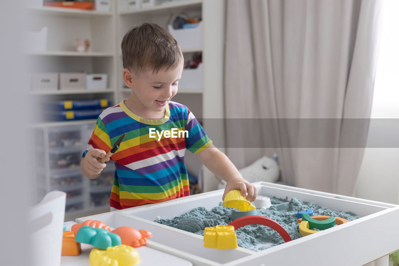 portrait of cute girl playing with toys on table