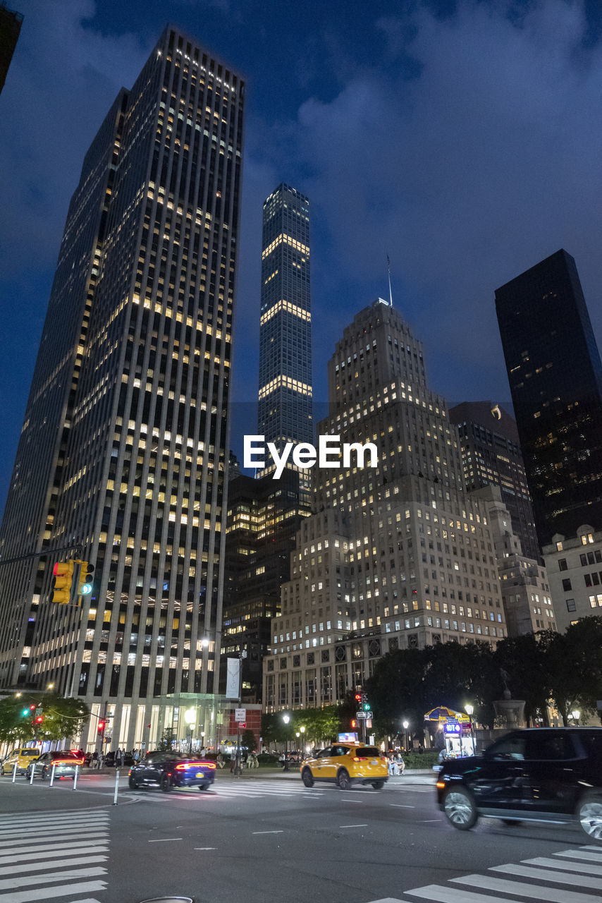 low angle view of illuminated buildings in city at night