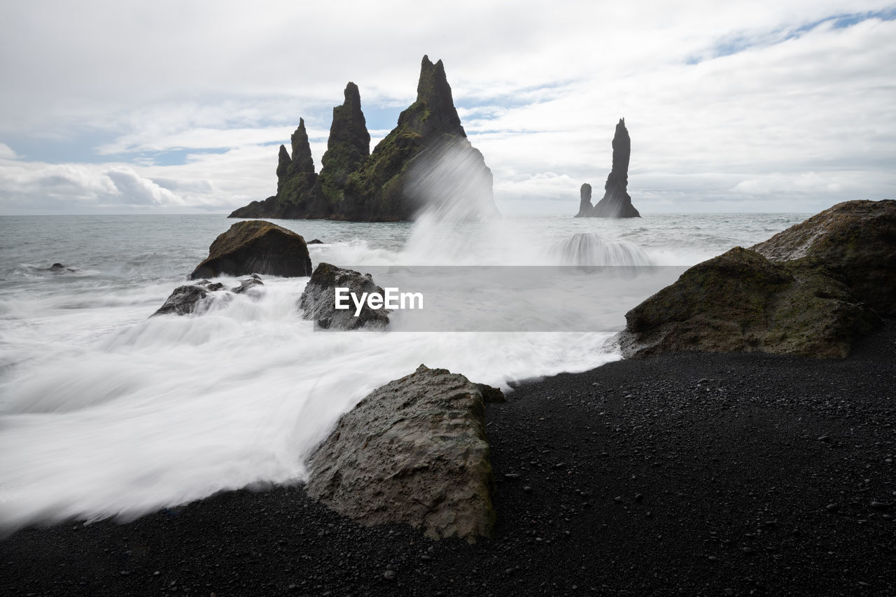 Scenic view of rocks in sea against sky