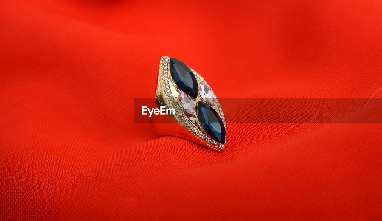 HIGH ANGLE VIEW OF RING ON RED METAL