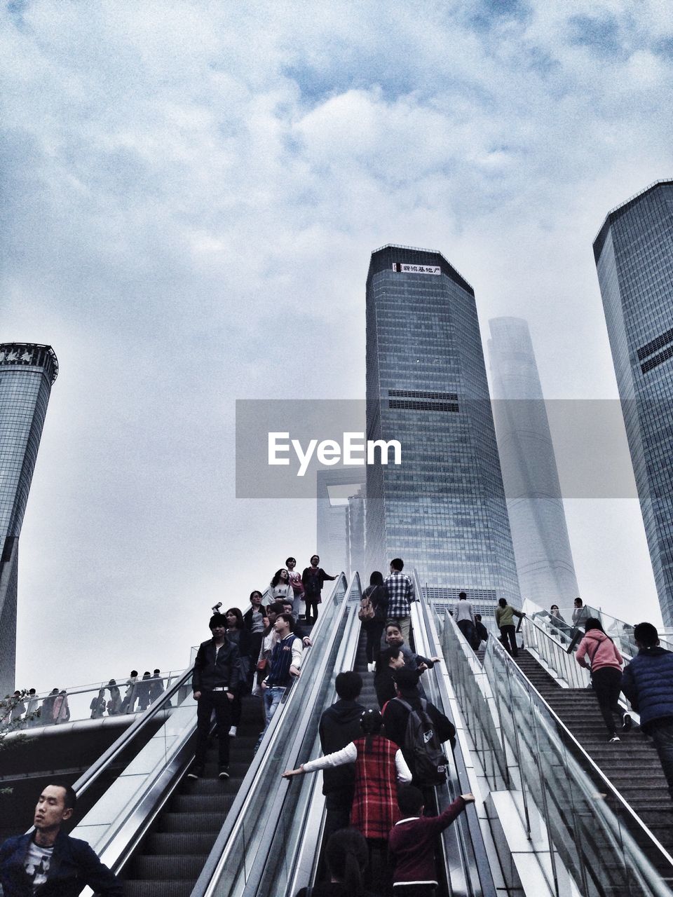 PEOPLE ON MODERN BUILDING AGAINST SKY IN CITY