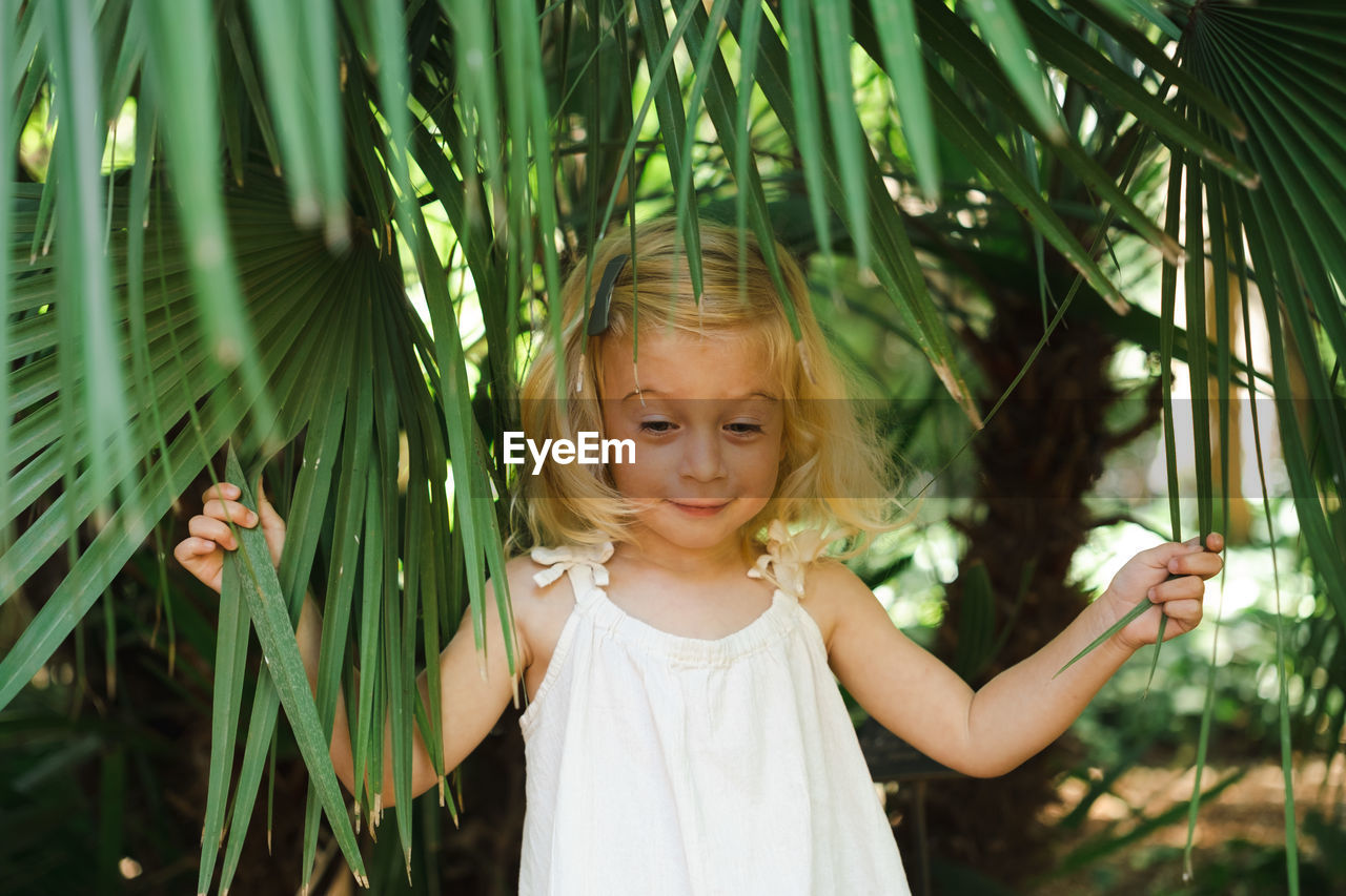 portrait of young woman standing by plants