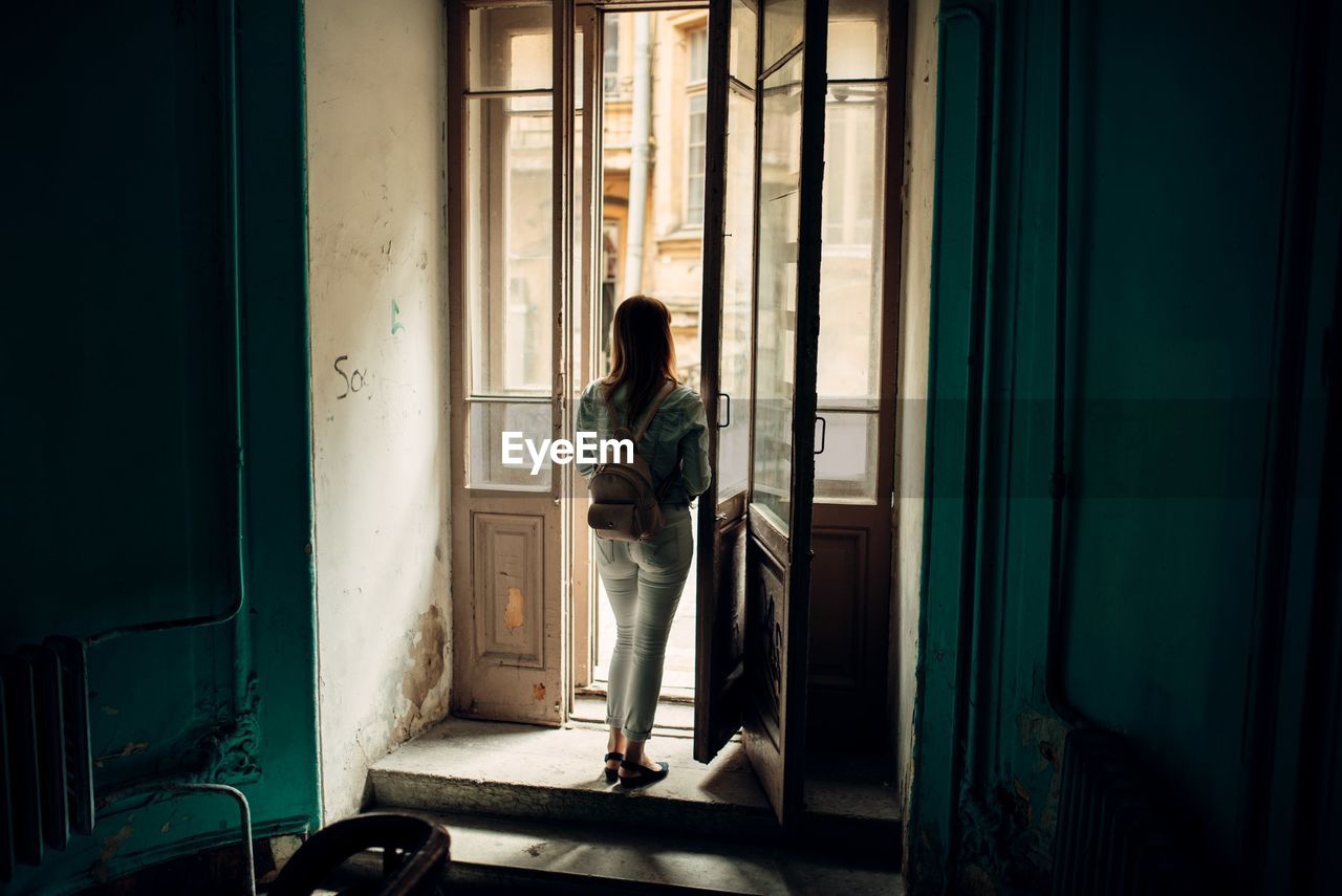 WOMAN STANDING BY WINDOW