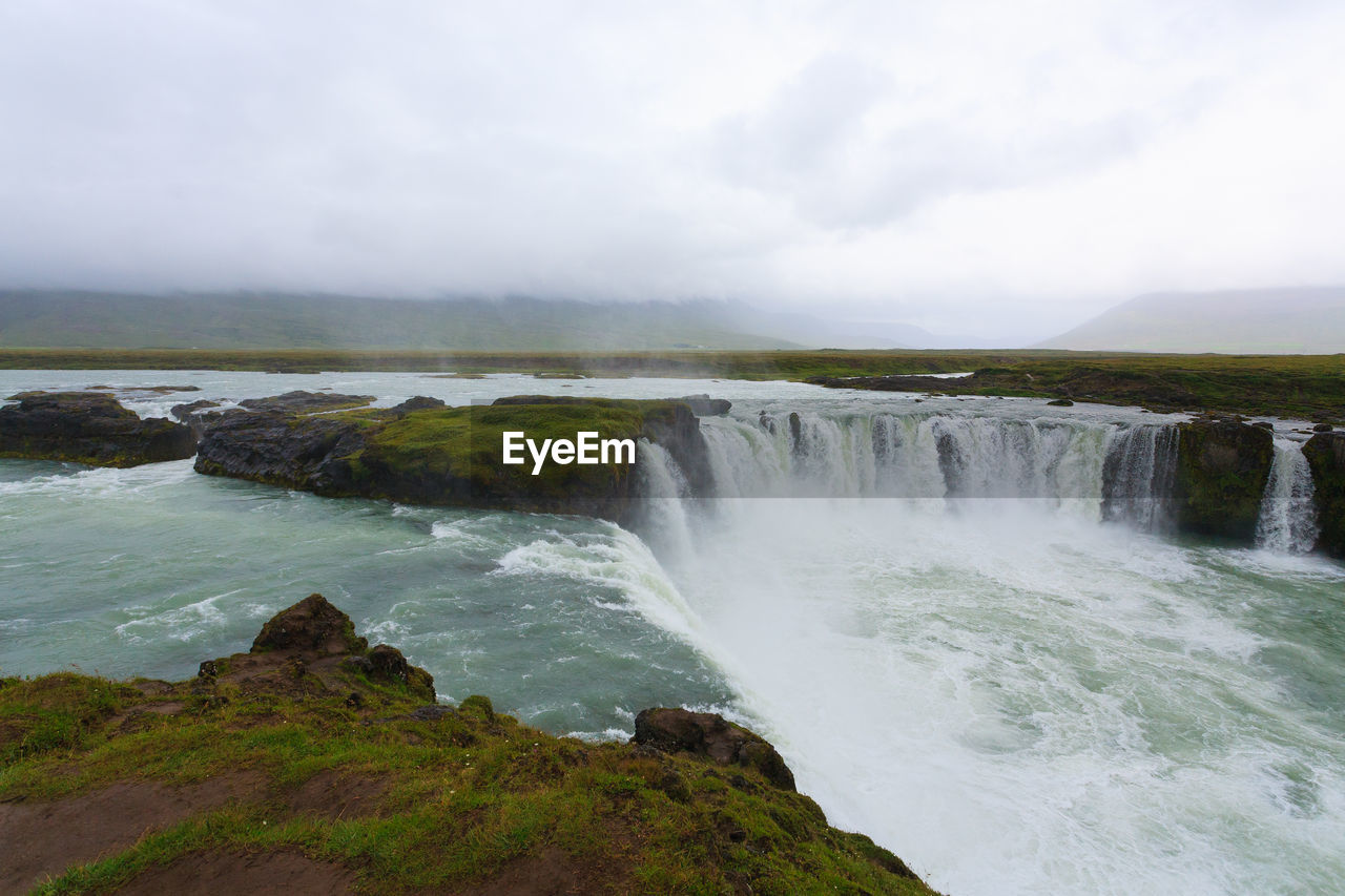 scenic view of waterfall against sky