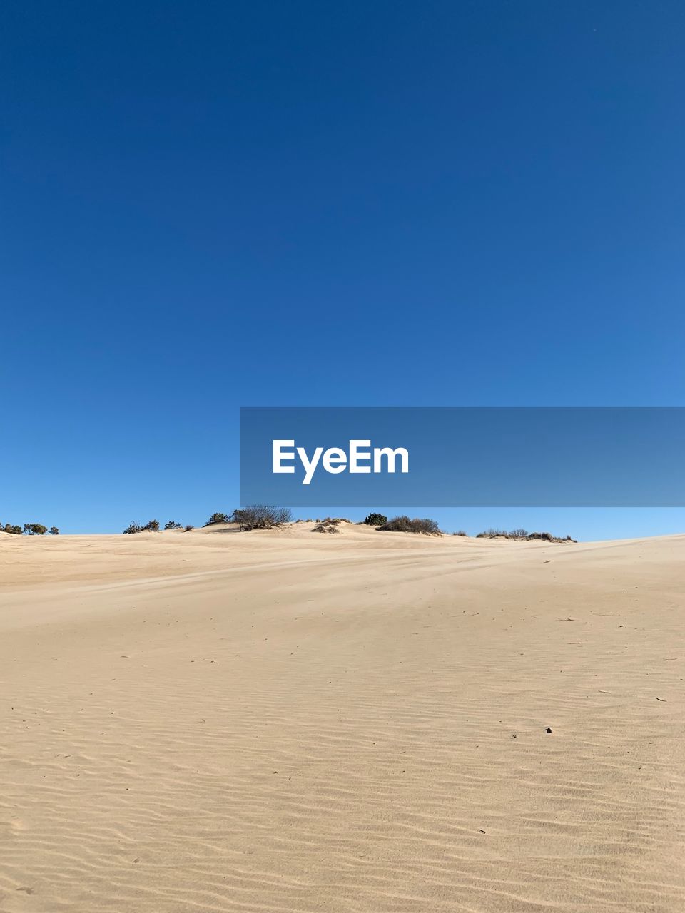 Scenic view of desert against clear blue sky