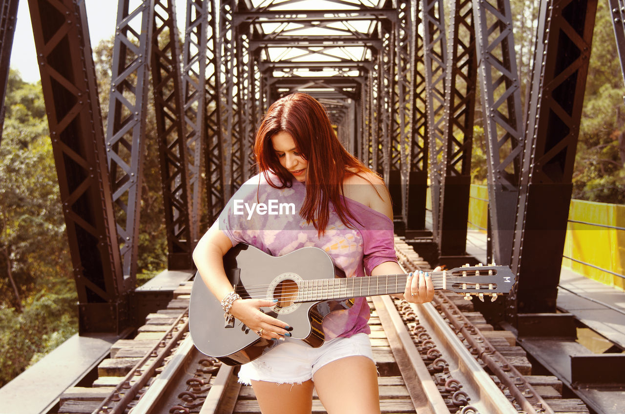 Portrait of young woman playing guitar