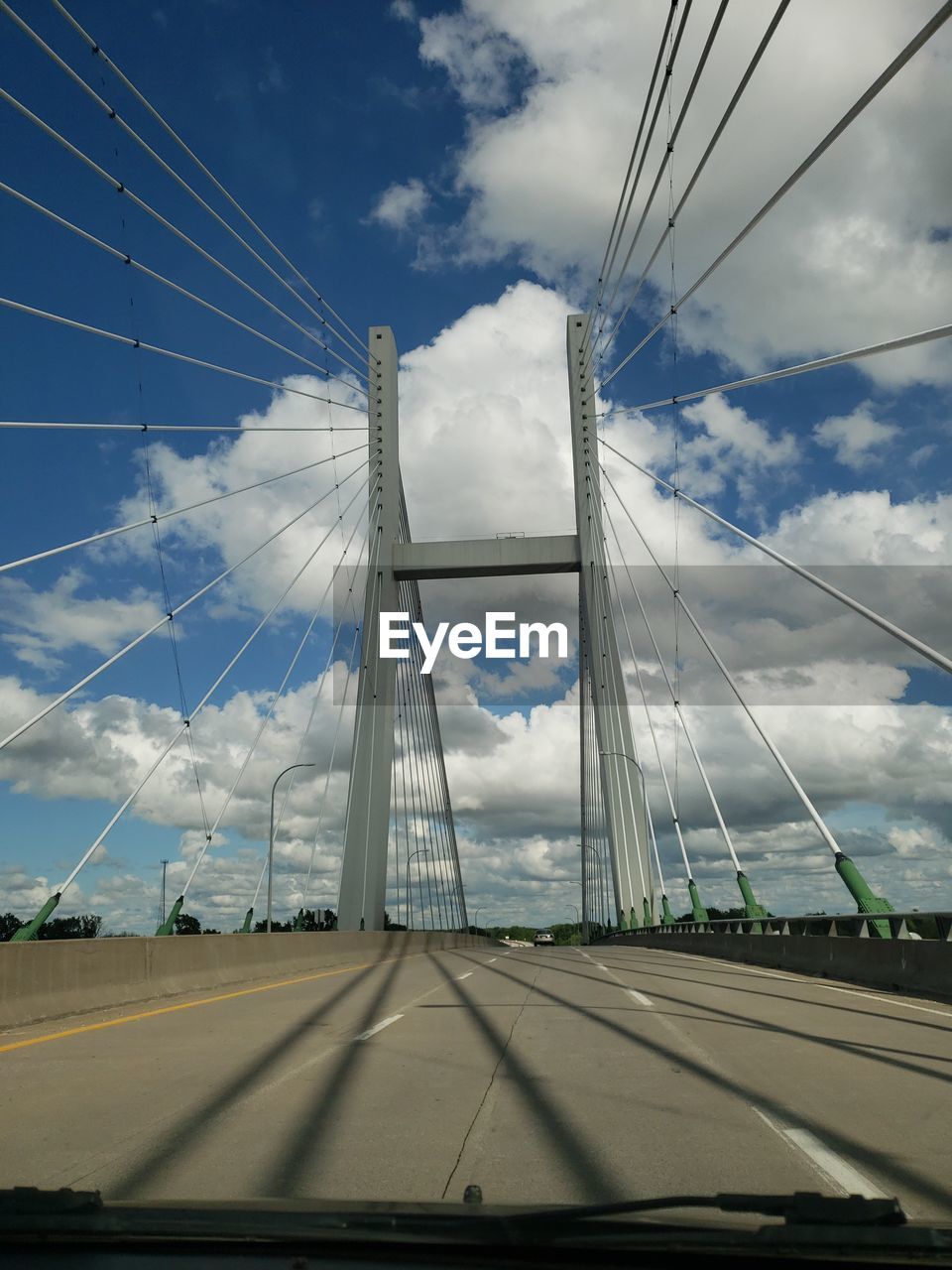 LOW ANGLE VIEW OF SUSPENSION BRIDGE AGAINST CLOUDY SKY