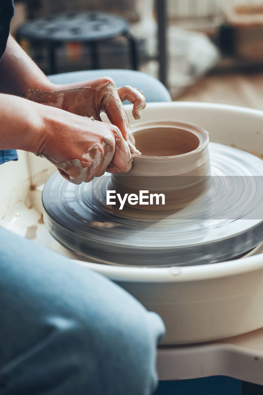 The female hands of potter model clay product on wheel