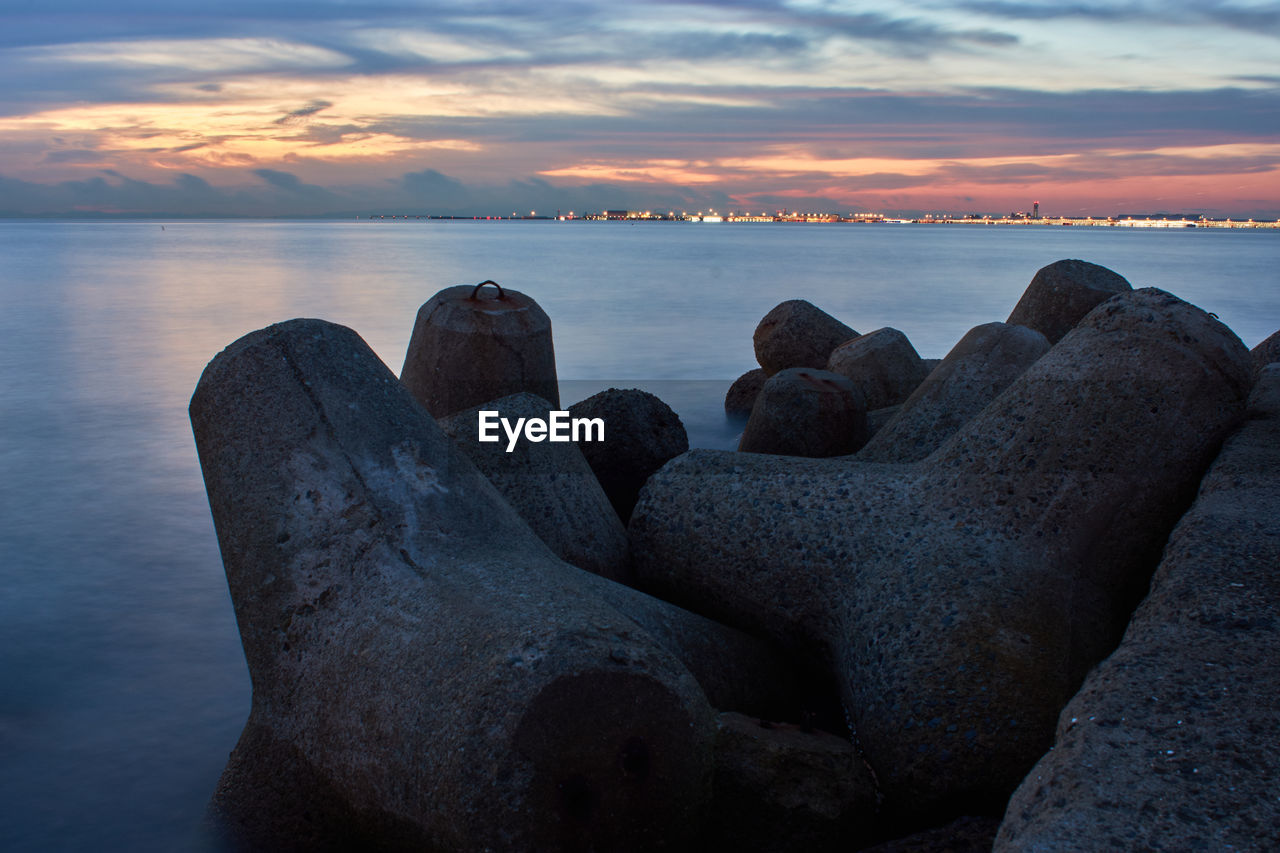 SCENIC VIEW OF ROCKS AT BEACH AGAINST SKY