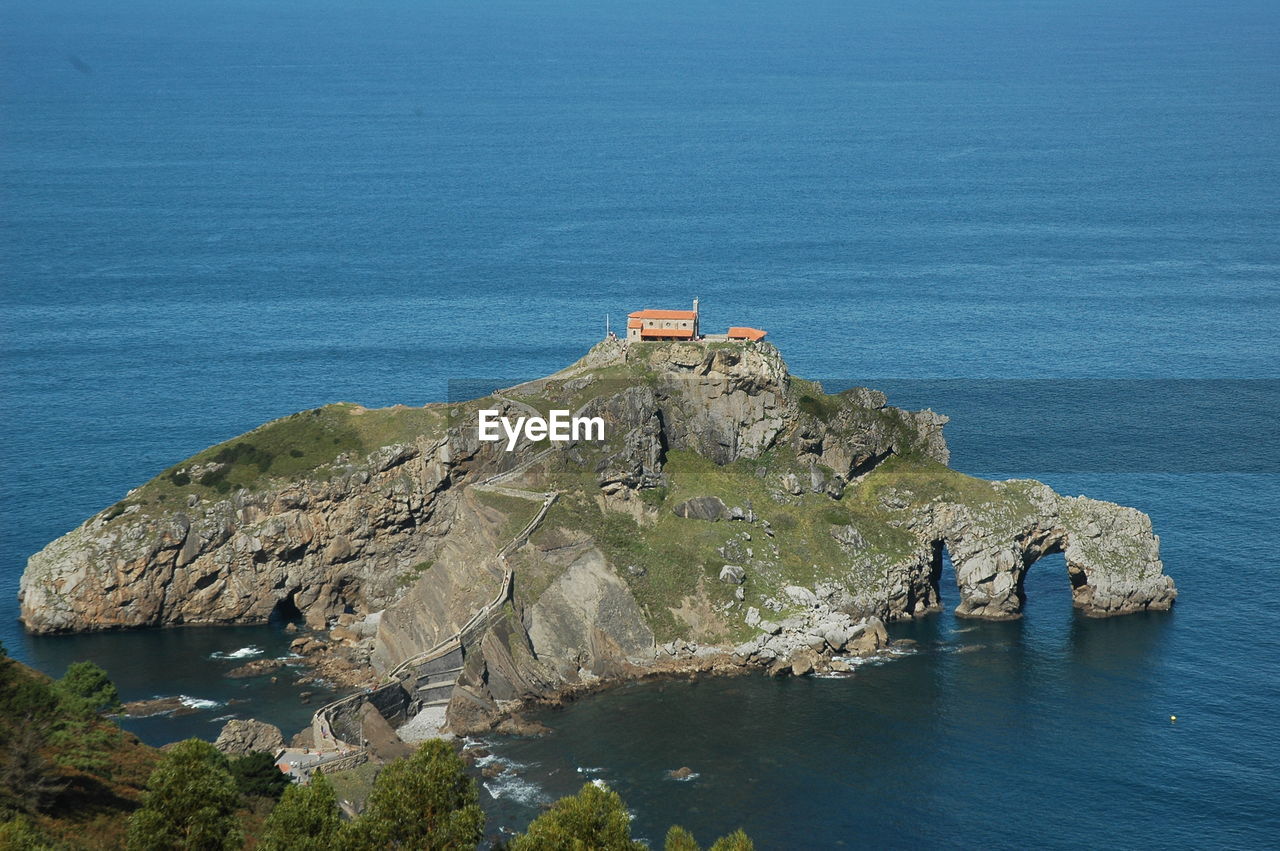 HIGH ANGLE VIEW OF ROCK FORMATIONS AT SEA
