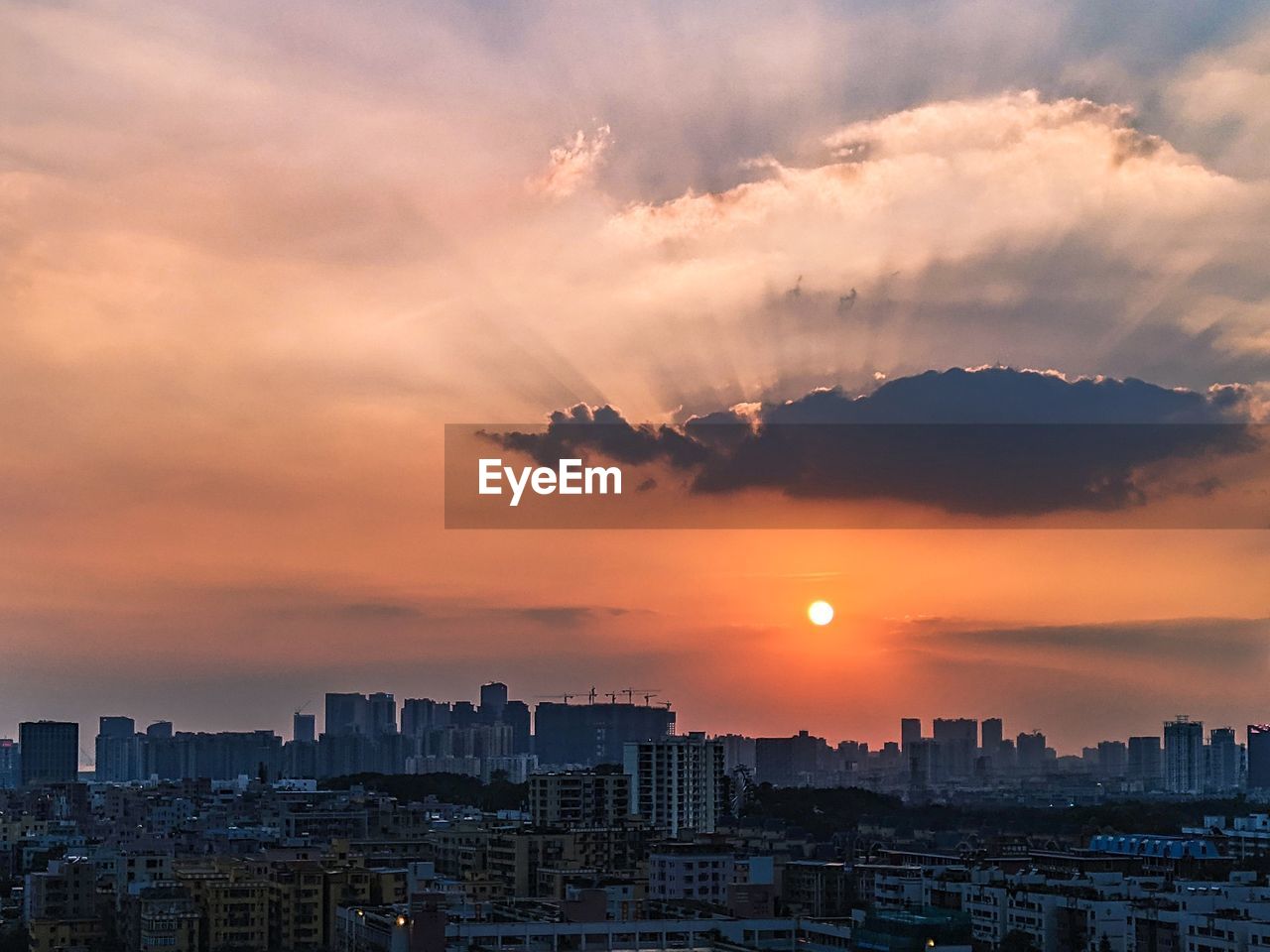 Aerial view of buildings against sky during sunset