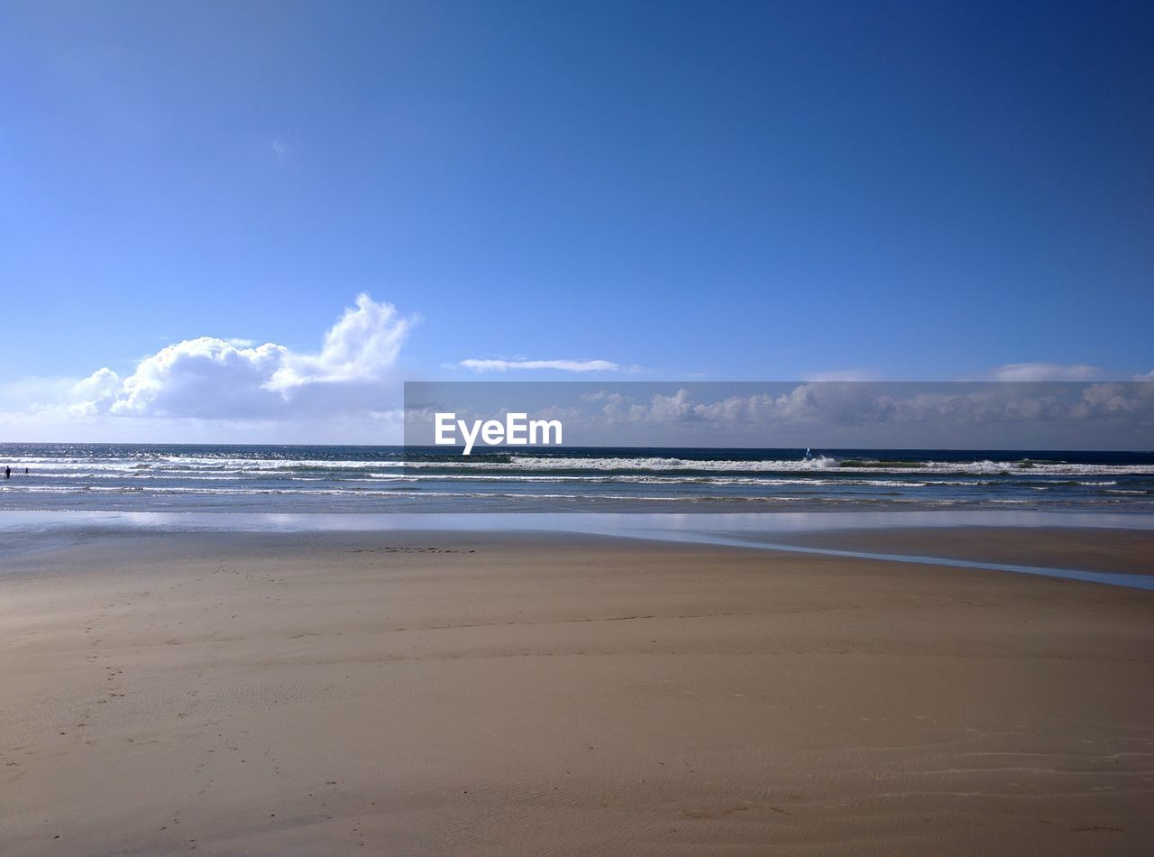 Scenic view of beach against cloudy sky