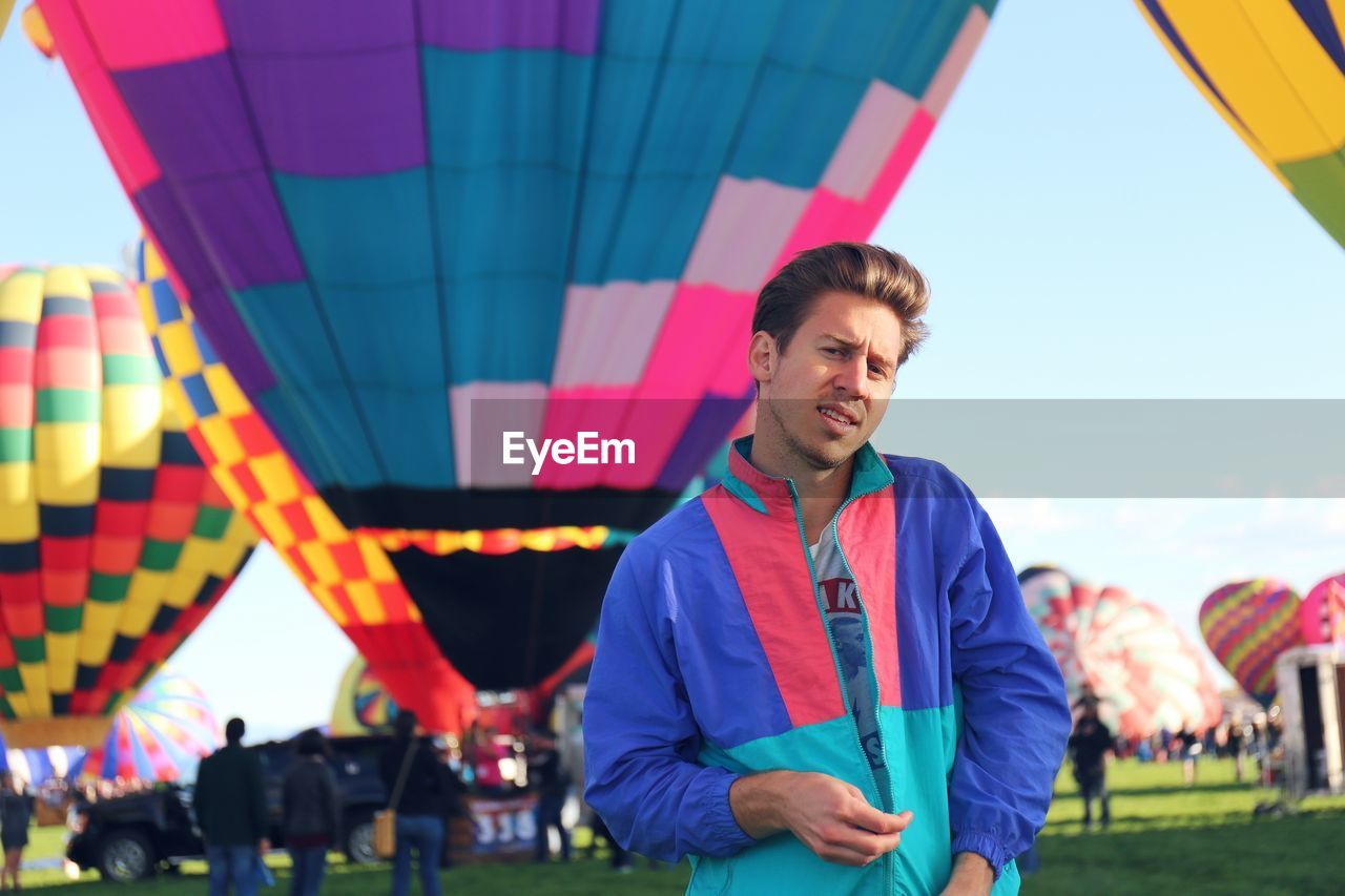 View of man standing against field of hot air balloons