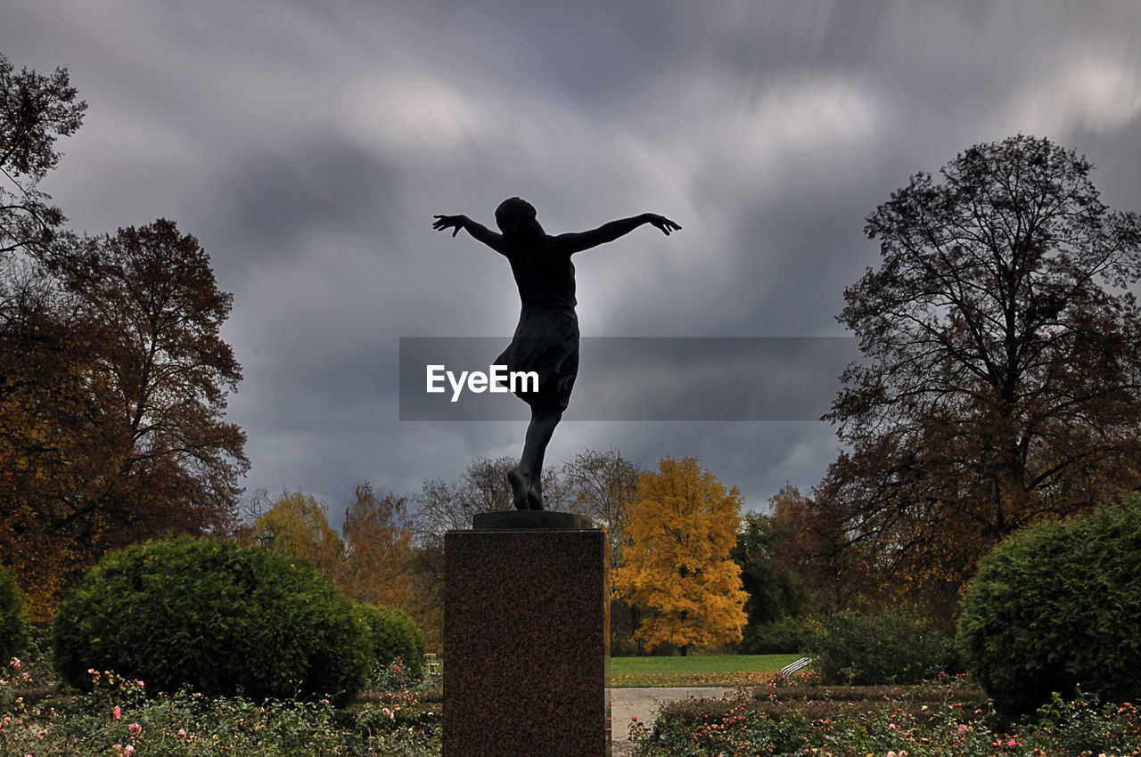 STATUE AGAINST TREES AND SKY