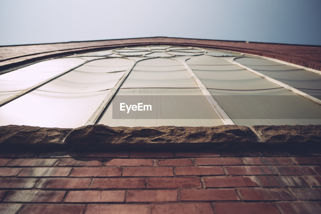 Low angle view of building window against clear sky