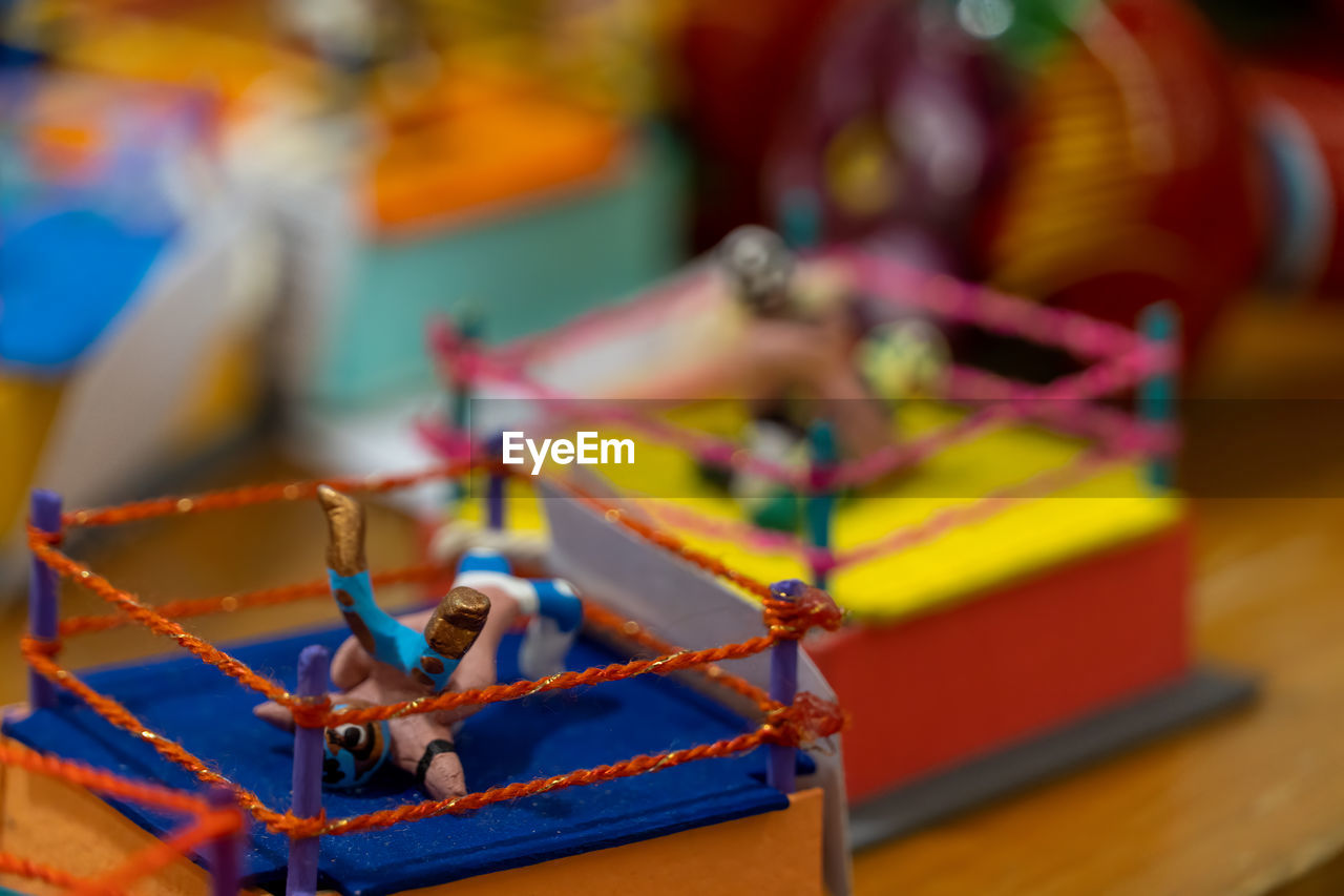 toy, focus on foreground, close-up, multi colored, no people, selective focus, indoors, wood, day